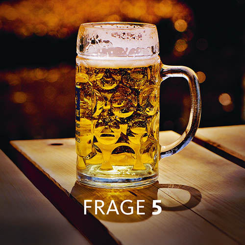 Mit Bier gefüllte Maß auf einem Tisch; Text im Bild: Frage 5