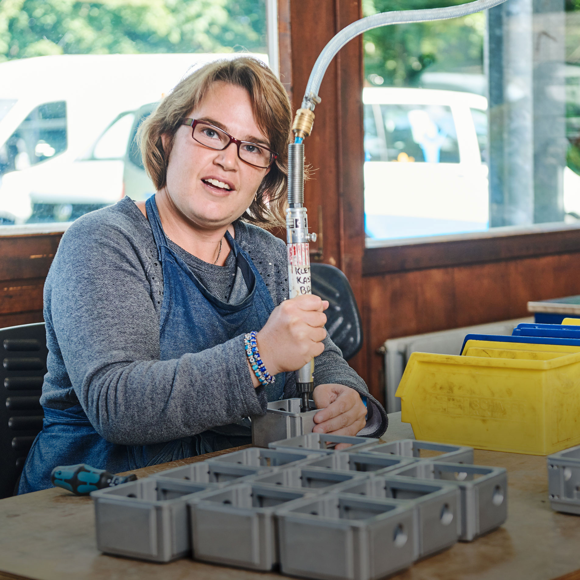 Eine Frau arbeitet in einem Metallverarbeitungsraum