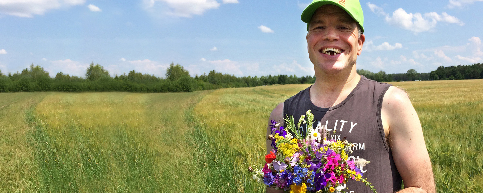 Ein Bewohner steht im Freien und hält einen Blumenstrauß
