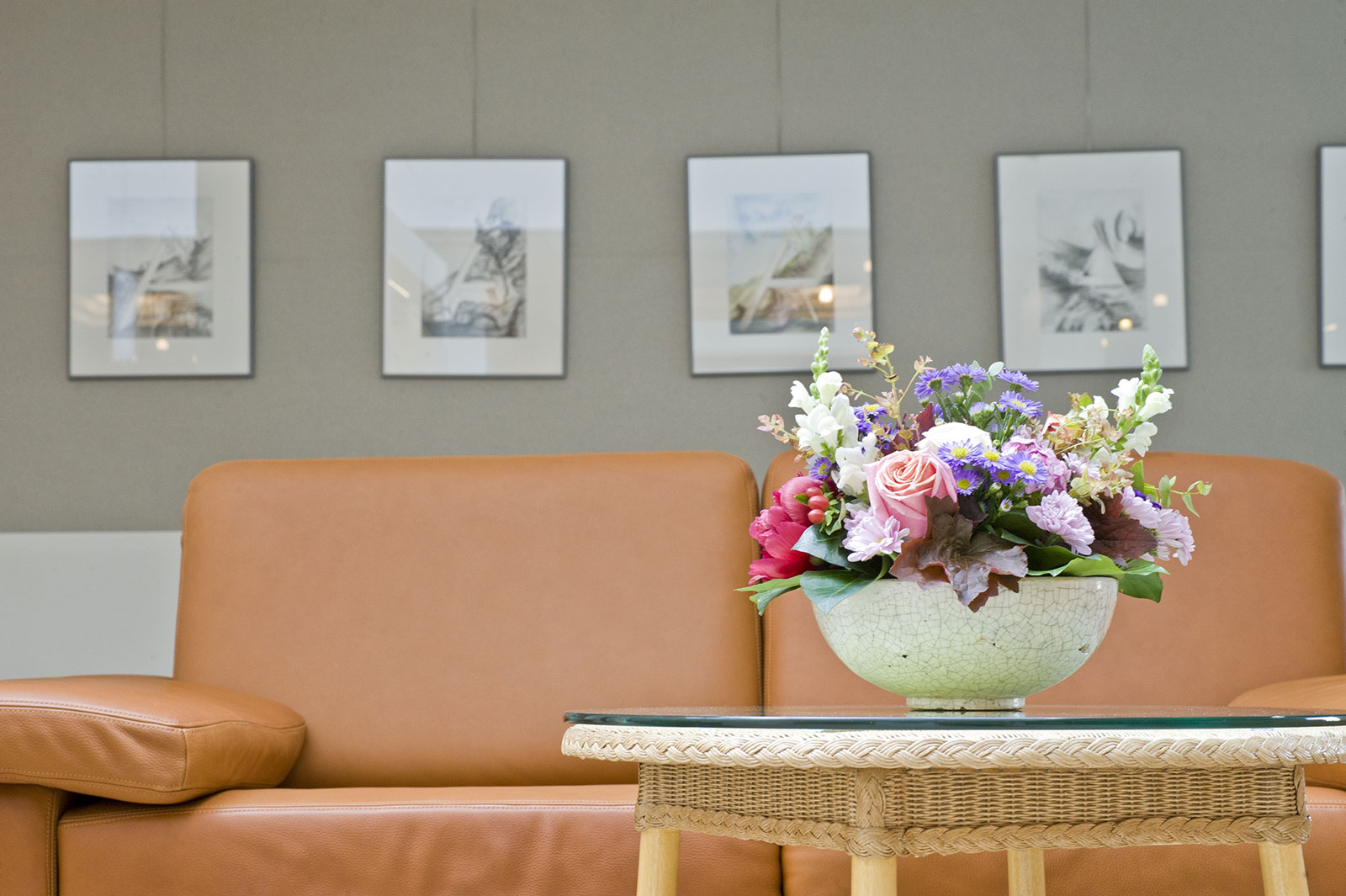Blumenstrauß auf einem Tisch vor einem Ledersofa