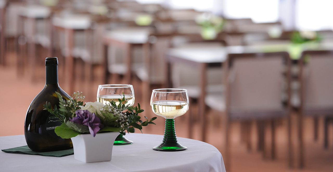 Zwei Gläser und ein Blumenstrauß auf einem Tisch im Restaurant