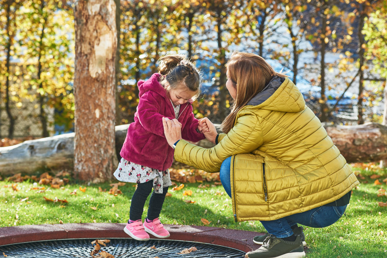 Eine Frau und ein Mädchen spielen in einem Garten 