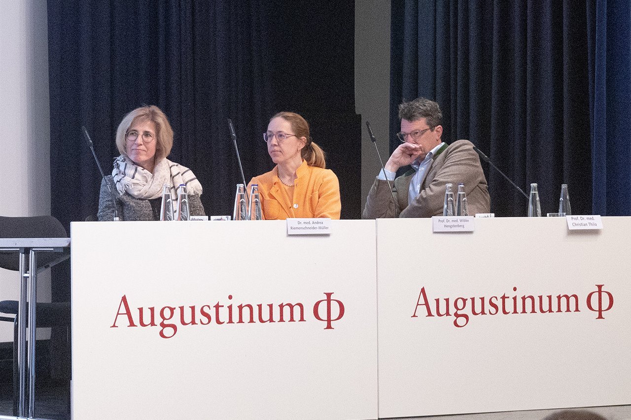 Der Vorsitz des ersten Symposiums - bestehend aus zwei Frauen und einem Mann - sitzt auf der Bühne 