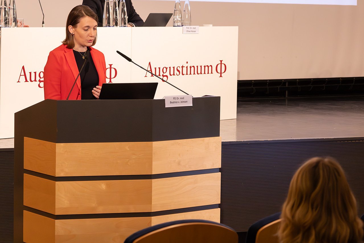 Die Referentin Dr. von Jeinsen steht an einem Rednerpult und spricht in das Mikrofon 