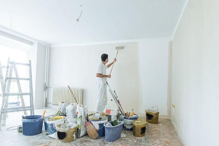 Ein Maler streich eine Wand weiß