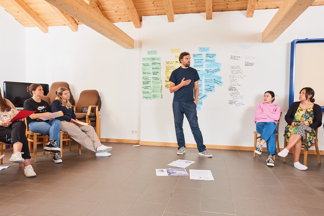 Teilnehmer*innen eines Seminars hören dem Seminarleiter zu