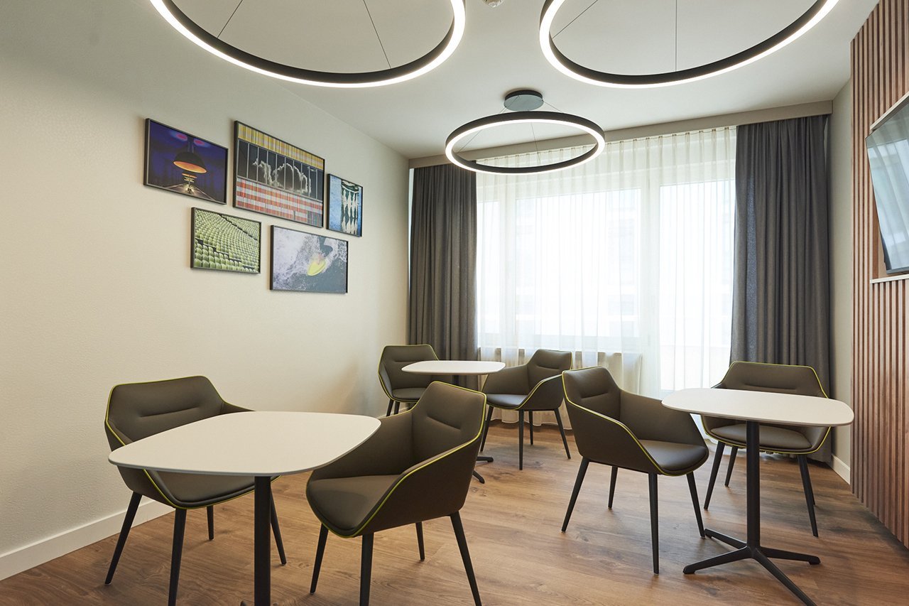 Mehrere Sitzmöglichkeiten mit Tischen in der Lounge der Wahlleistungsstation in der Augustinum Klinik 
