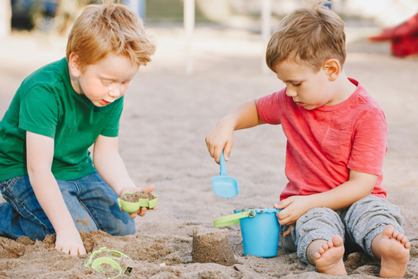 Zwei Kinder spielen im Sandkasten