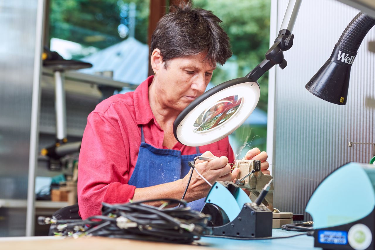 Eine Klientin arbeitet mit einem Vergrößerungsglas in der Elektronikabteilung