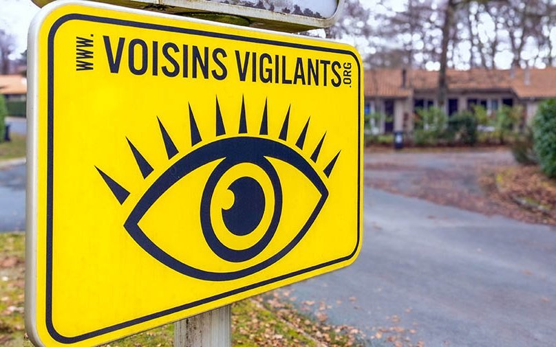 Das Schild am Eingang vieler französischer Ortschaften wirkt nicht unbedingt freundlich: ein weit geöffnetes Auge in schwarzen Konturen auf signalgelbem Hintergrund und darüber in ebenfalls schwarzen Lettern: Voisins Vigilants.