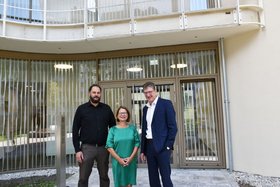 Der Architekt Tobias Karlhuber, die Direktorin der Augustinum Seniorenresidenz München-Neufriedenheim Christiane-Maria Rapp und der Vorsitzende der Konzerngeschäftsführung des Augustinum Joachim Gengenbach stehen vor dem Verbindungsdurchgang zwischen den Neubauten.