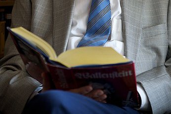 Aufgeschlagenes Buch auf dem Schoß eines Mannes