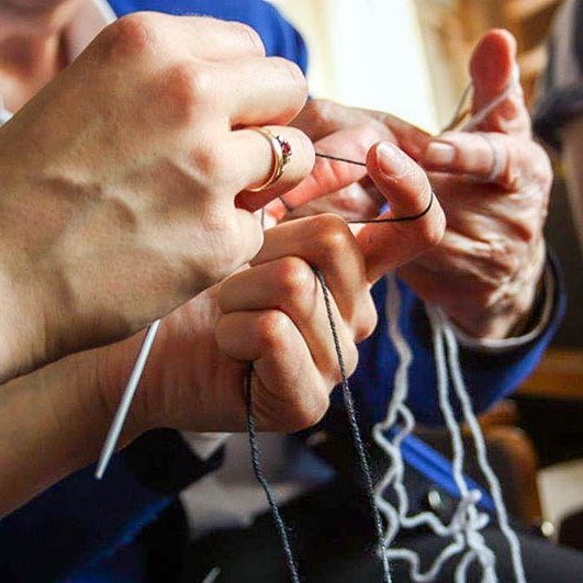 Strickende Hände von zwei Damen