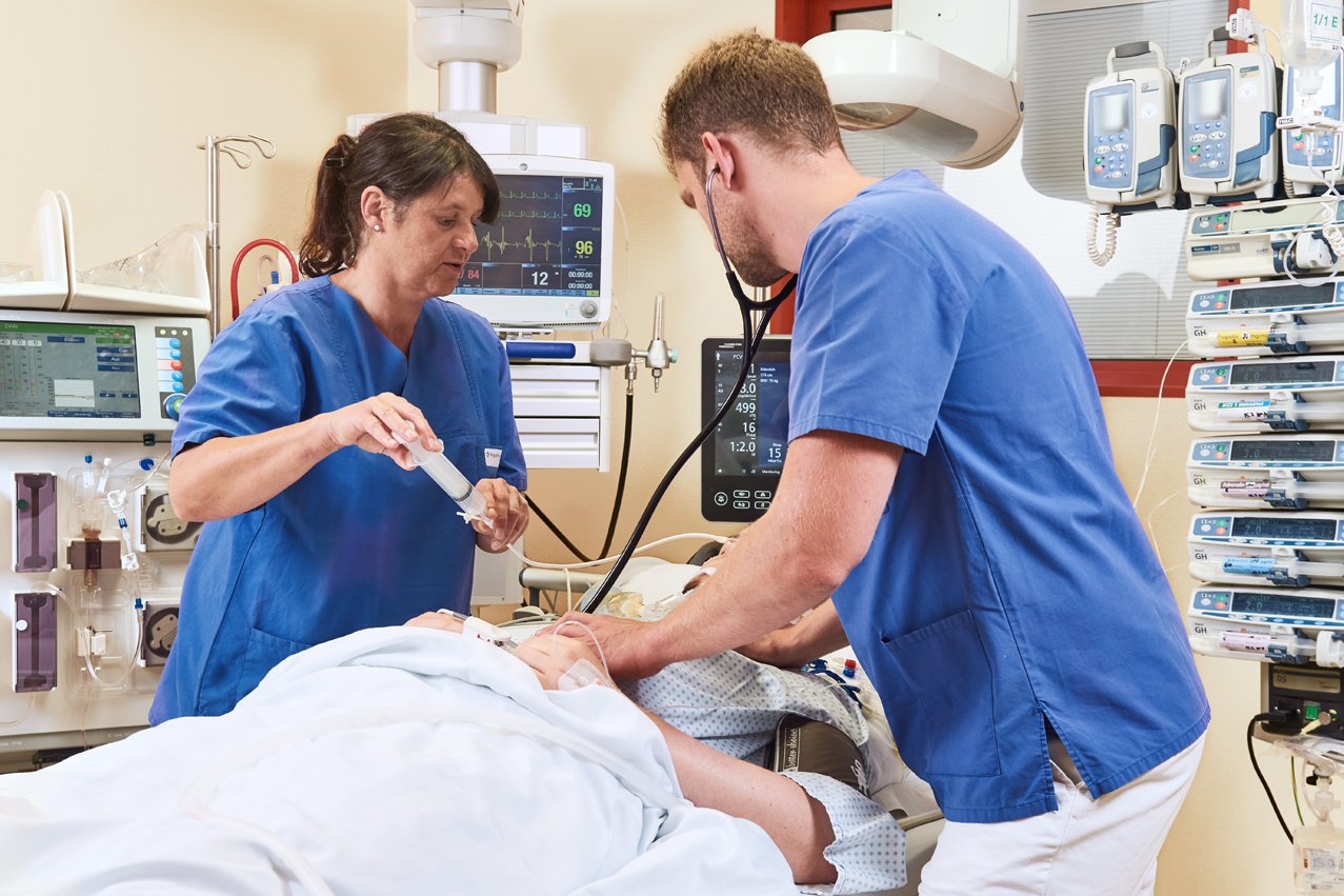 Eine Gesundheits- und Krankenpflegerin und ein Arzt versorgen eine Patientin auf der Intensivstation der Augustinum Klinik.