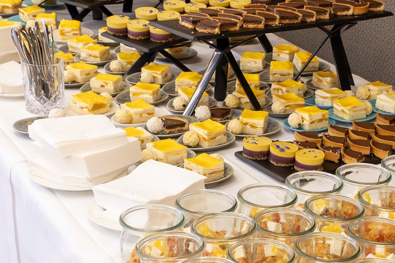 Viele kleine Kuchen auf einem Tisch beim Büffet der Veranstaltung