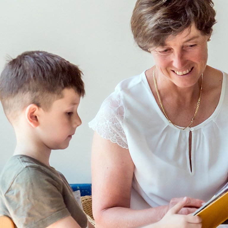 Eine Frau und ein Kind lesen gemeinsam ein Buch