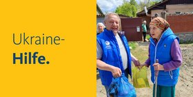 Zwei Personen aus der Ukraine bekommen Hilfsgüter überreicht. Zu lesen ist Ukraine Hilfe