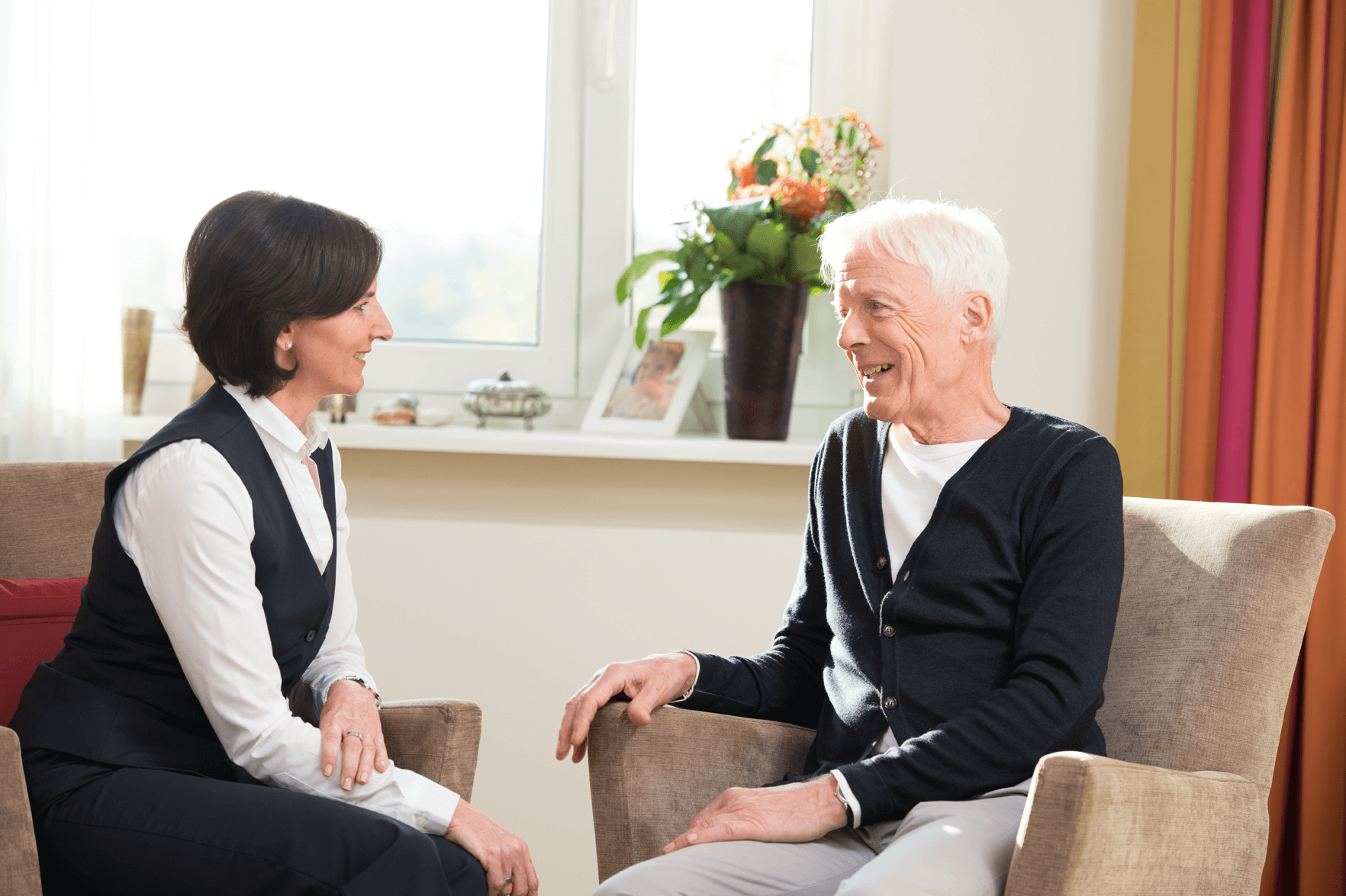 Mitarbeiterin des Augustinum Bewohnerservices im Gespräch mit einem Bewohner