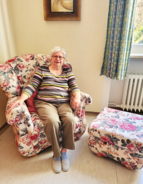 Foto der Bewohnerin Dagmar Kastner, die in einem Sessel sitzt