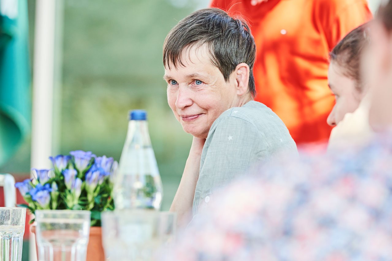 Eine Frau sitzt an einem Tisch im Freien