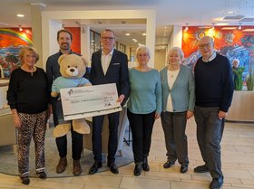 Ein Gruppenbild von dem Direktor des Augustinum Dortmund, Malte Schmidt vom Deutschen Kinderhospizdienst und Senior*innen mit dem Spendenscheck für den Deutschen Kinderhospizdienst