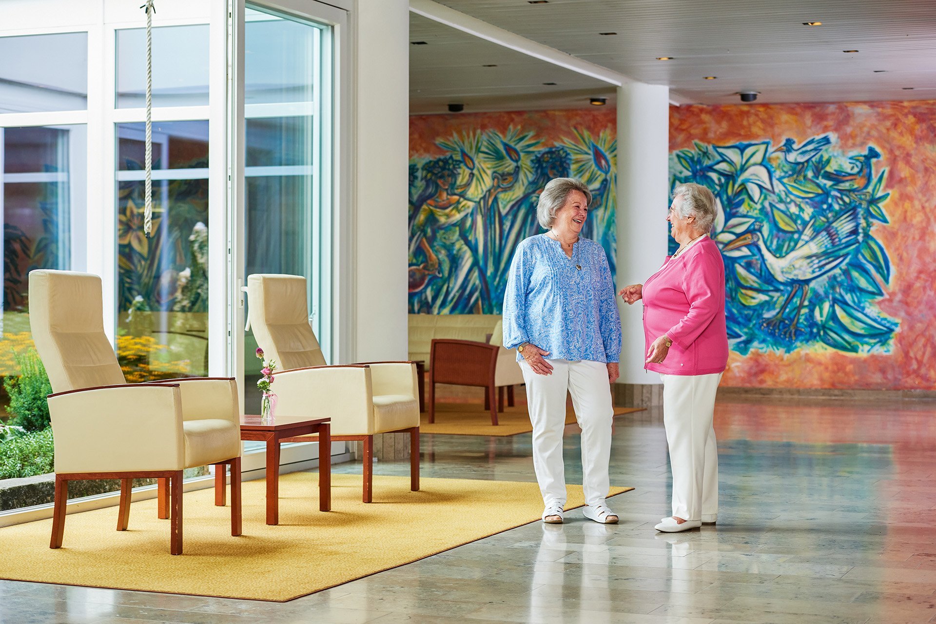 Zwei Seniorinnen unterhalten sich im Foyer der Seniorenresidenz 