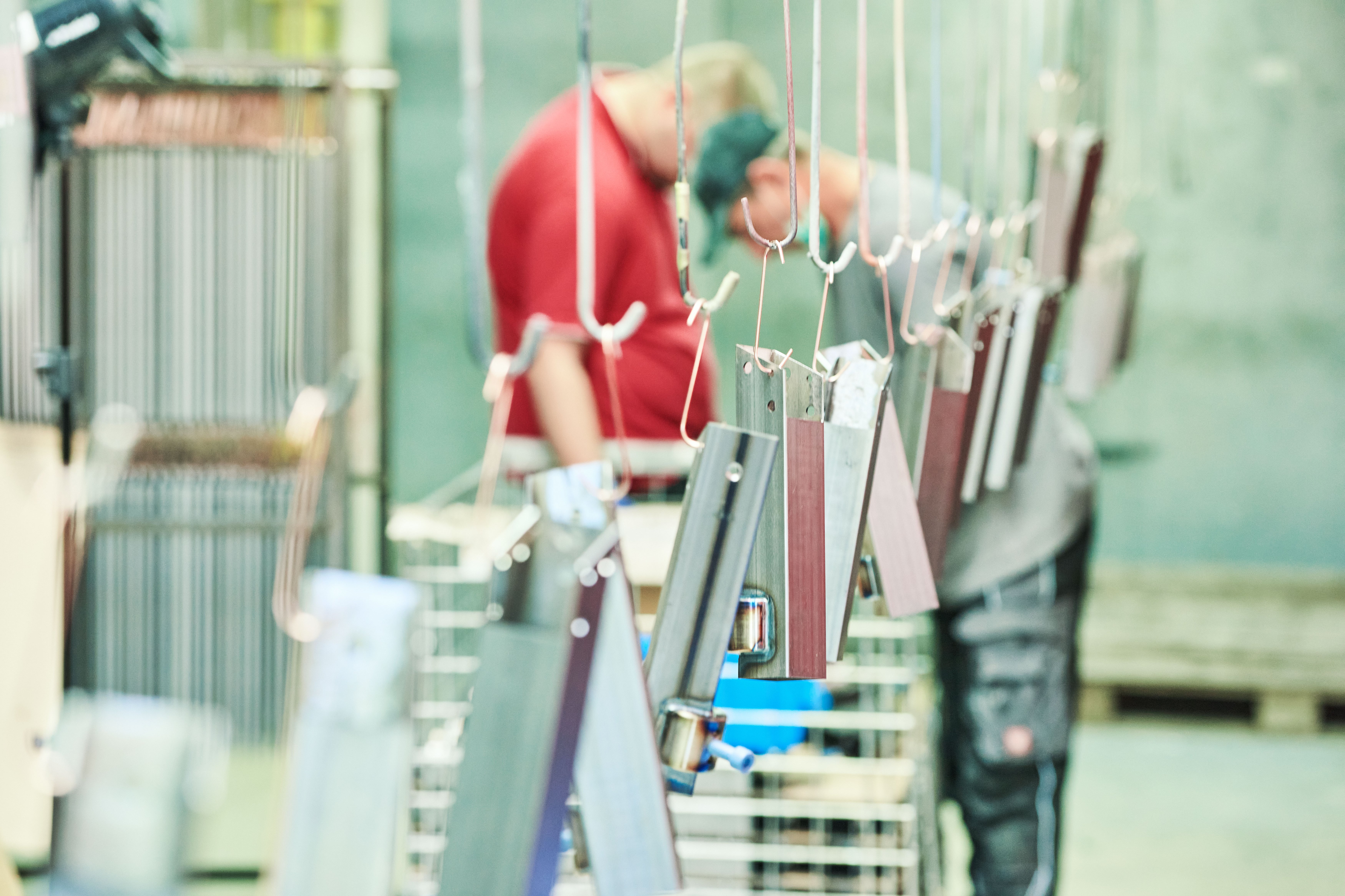 Zwei Klienten bei ihrer Tätigkeit im Bereich Pulverbeschichtung