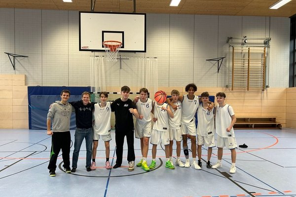 Ein Gruppenfoto der Basketballmannschaft der Samuel Heinicke Realschule in einer Turnhalle