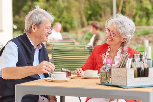 Zwei Senior*innen trinken auf der Terrasse des Vierundsiebzig einen Kaffee
