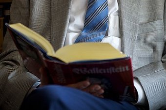 Ein Mann hält ein aufgeschlagenes Buch