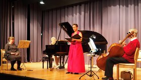 Vier Musiker*innen sind auf einer Bühne und spielen ein Konzert