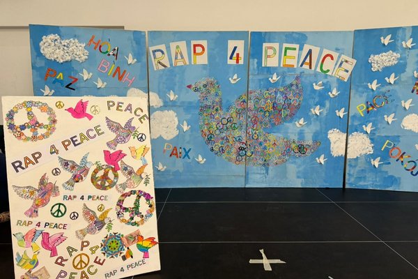 Plakate mit bunten Tauben und Peace-Zeichen, sowie der Aufschrift "Rap4Peace"