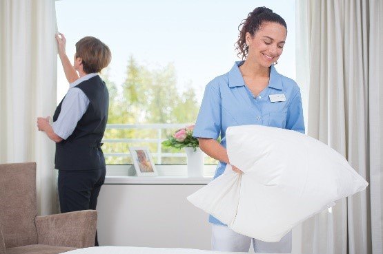 Zwei Augustinum Mitarbeiterinnen beim Bettenmachen und Richten der Vorhänge