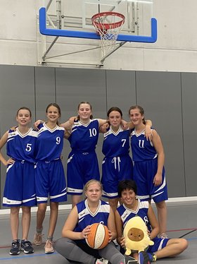 Gruppenbild der Basketball-Spielerinnen der Samuel-Heinicke-Realschule vor einem Basketballkorb