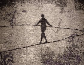 Ein Kunstwerk in Grau-Tönen, das eine balancierende Person zeigt 