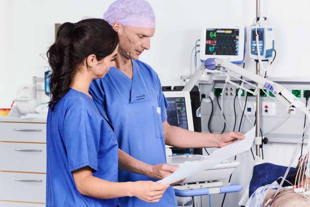 Arzt und Gesundheits- und Krankenpflegerin kontrollieren in der Chest Pain Unit das EKG eines Notfallpatienten