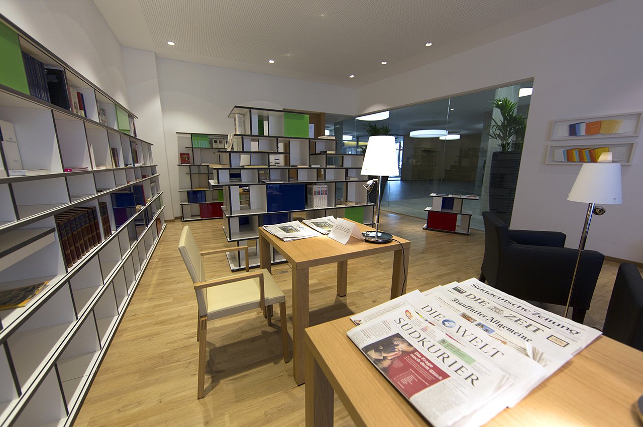Verschiedene Tageszeitungen und Tausende von Büchern warten in der Hausbibliothek auf ihre Leser*innen. 