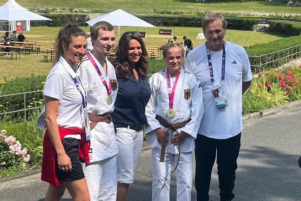 Zwei Beschäftigte der Augustinum Tagesstätten mit ihrer Goldmedaille, Katharina Witt und zwei weitere Personen des Judo-Teams
