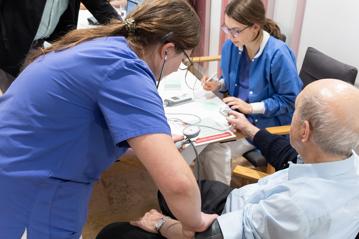 Eine Mitarbeiterin der Augustinum Klinik misst den Blutdruck eines Seniors