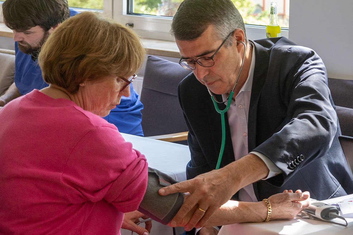 Chefarzt Dr. Klaus Thürmel misst den Blutdruck einer Besucherin 