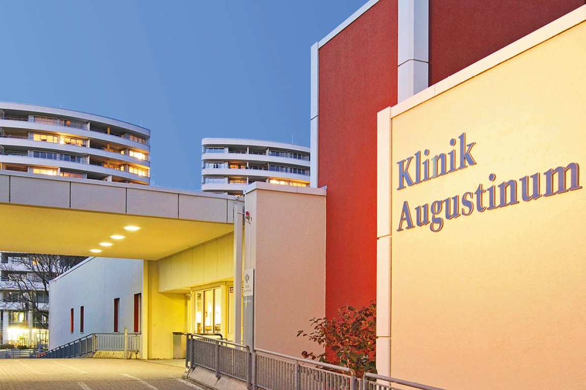 Bild der Auffahrt und des Eingangsbereichs der Augustinum Klinik in der Dämmerung