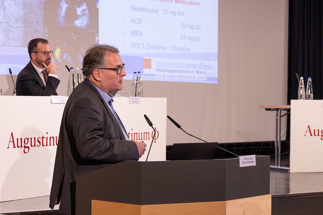 Nahaufnahme des Referenten Dr. von Bardeleben am Rednerpult vor der Bühne