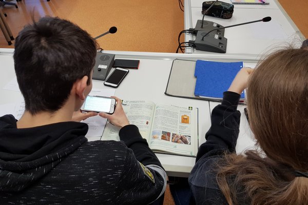 Zwei Schüler*innen beschäftigen sich mit den Inhalten eines Chemie-Buchs