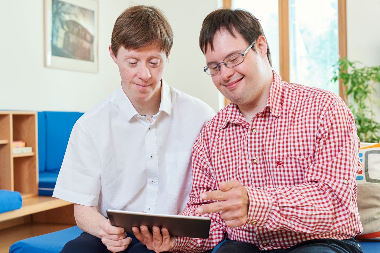 Zwei Bewohner blicken auf ein Tablet