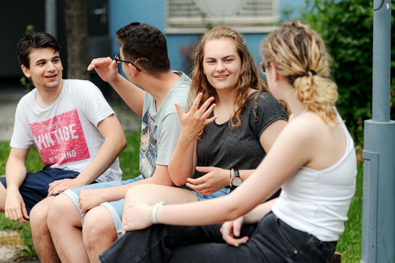 Freizeit Jugendliche unterhalten sich in Gebärdensprache im Garten