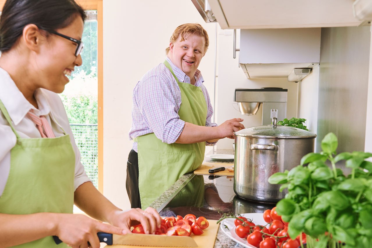 Ein Bewohner und eine Mitarbeiterin kochen gemeinsam