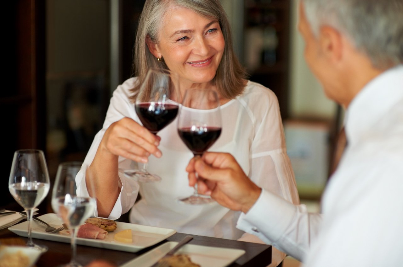 Frau und Mann stoßen mit Rotwein an