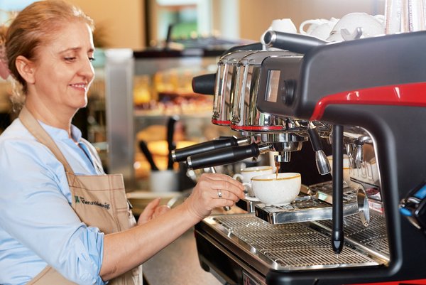 Eine Mitarbeiterin des Vierundsiebzig macht einen Kaffee