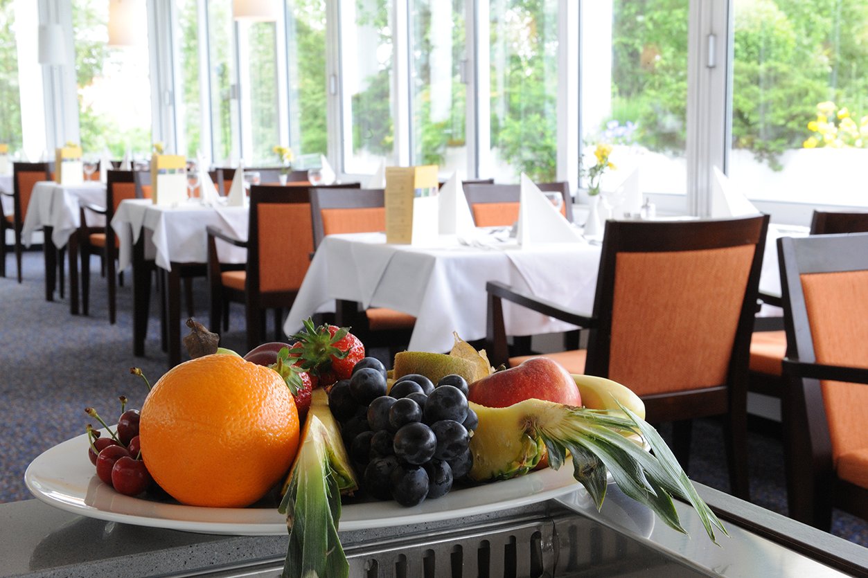 Ein Obstkorb mit den gedeckten Tischen des Restaurants im Hintergrund