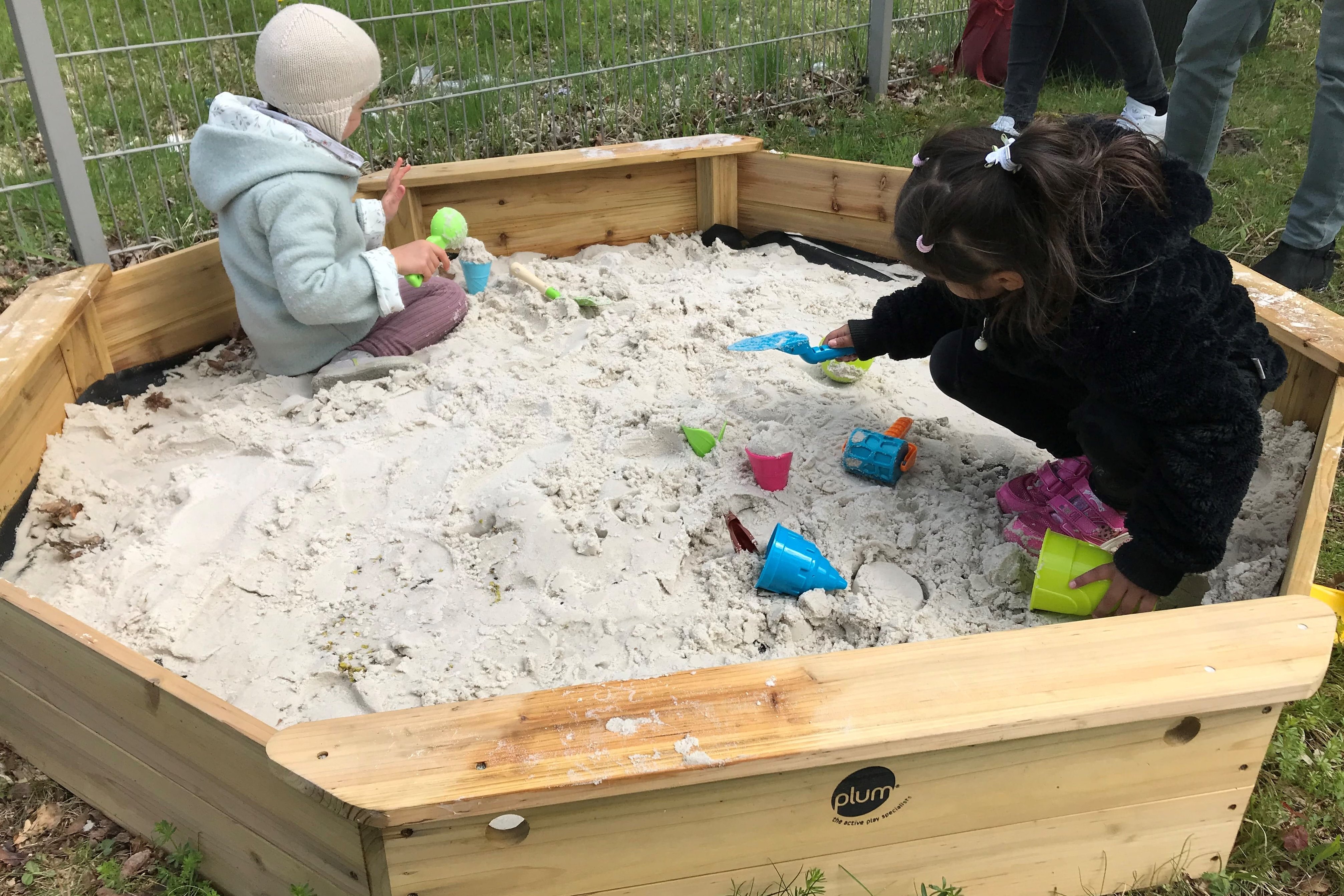 Zwei Kinder spielen in einem Sandspielbereich einer Frühförderstelle des Augustinum 